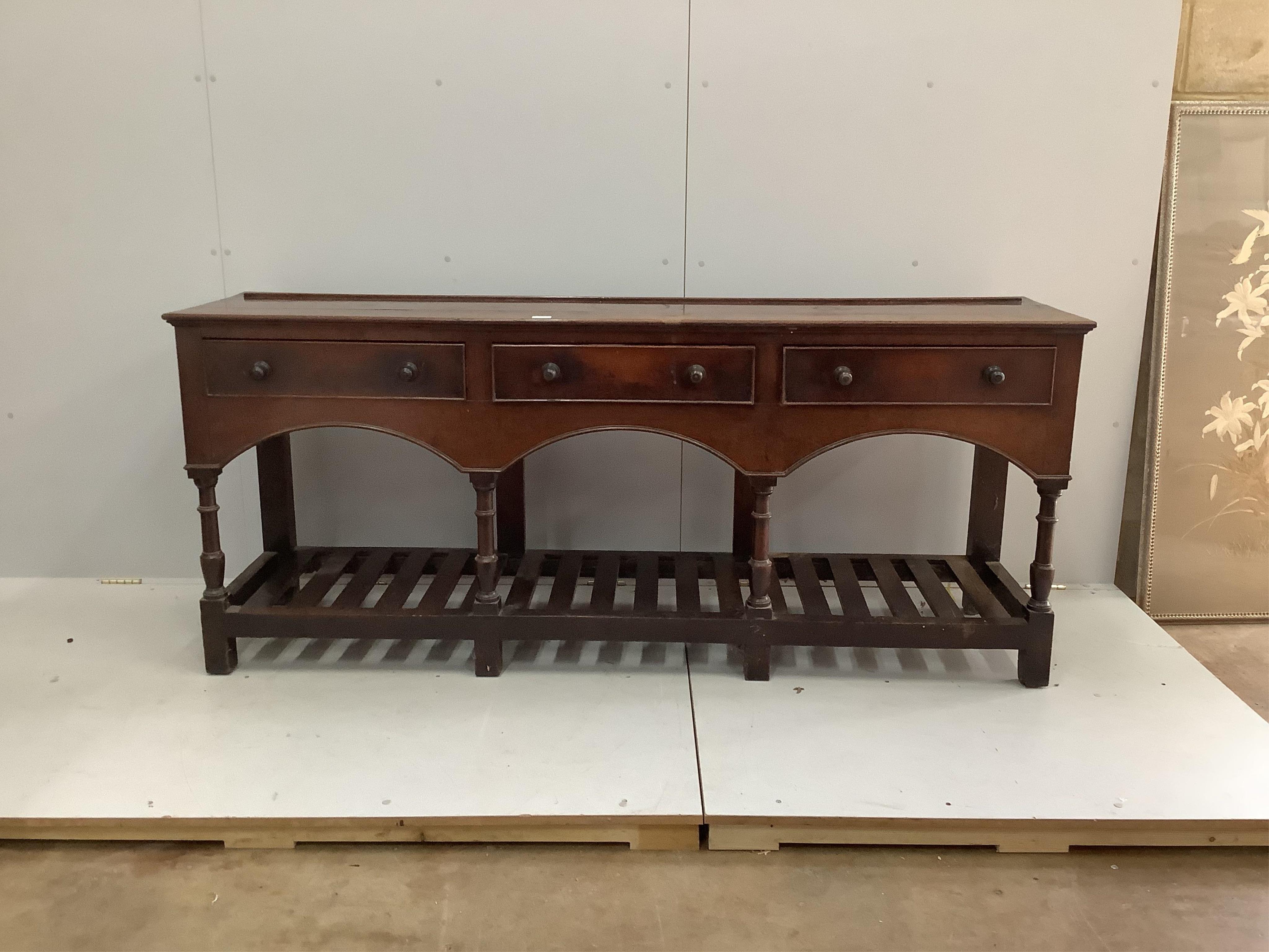 A mid 18th century oak potboard low dresser, fitted three drawers with bronze knob handles, width 194cm, depth 49cm, height 82cm. Condition - fair